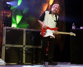 Ca. 2000, in front of dual Fender Vibro-King combos and extension cabs. Note Fishman Powerbridge tremolo and control for Fishman piezo transducer saddle-pickup system.