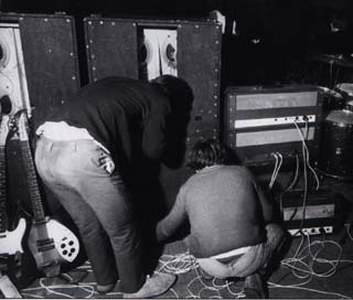 Rear view of the Marshall 8×12 cabinets, with top portion open-back design. The amplifiers are ’65 1959T JTM100 Super Lead Tremolo (top), ’67 1967 Marshall Major Lead (“Pig”), and on the ground, a Marshall JTM45 100 Super PA for vocals.