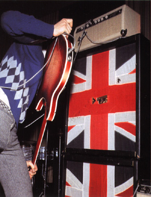 Click to view larger version. Ca. 1965, feeding back a 1964 Rickenbacker 360/12 Export through an early “stack” of Marshall 4×12 cabinets powered by a Fender Bassman atop the stack, which is daisy-chained to a custom Fender Pro head at lower right.